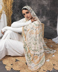 Woman wearing a floral hijab and white outfit sitting on a textured rug.